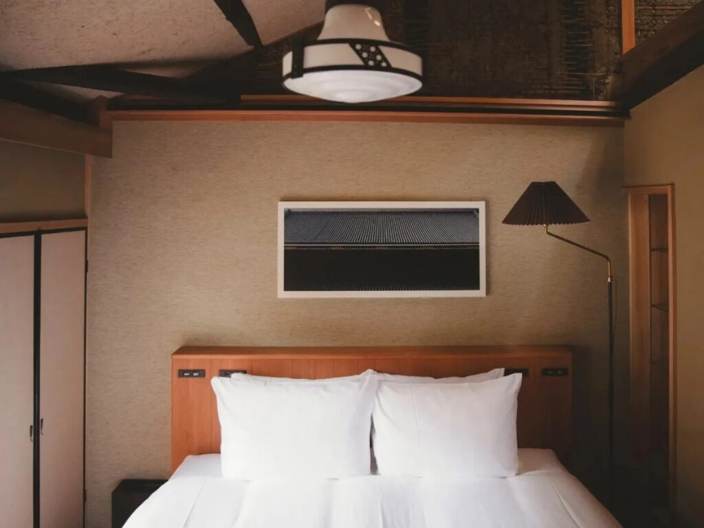 Genji Kyoto hotel bedroom with minimalist headboard and artwork inspired by The Tale of Genji.