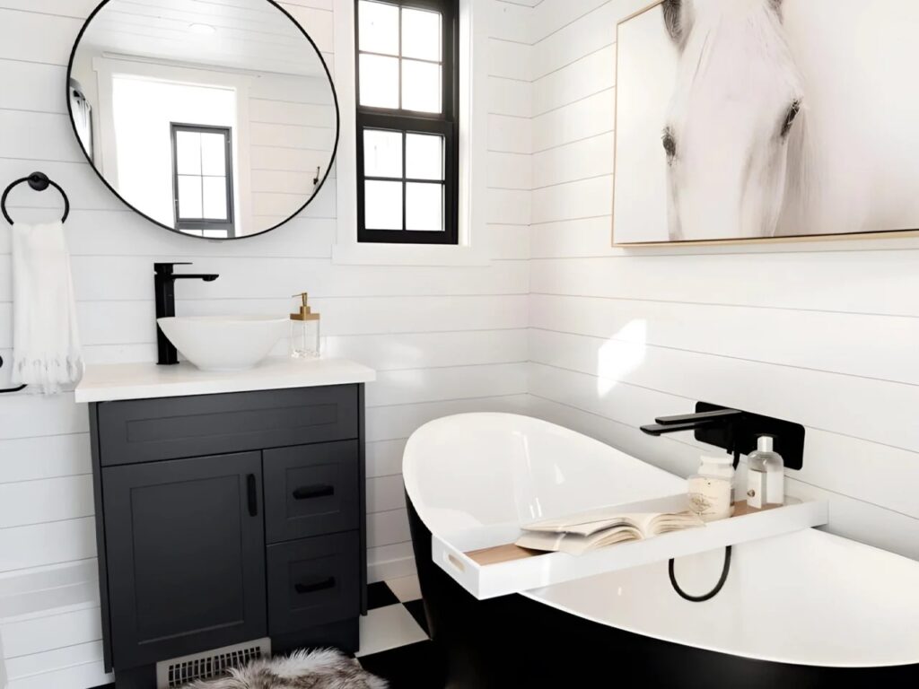 Luxury bathroom in Daphne tiny house featuring a black freestanding bathtub and modern vanity.