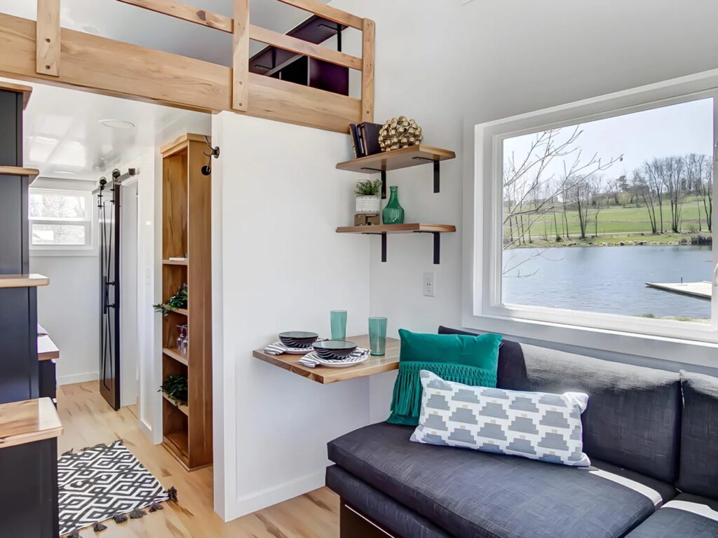 View from the living area towards the loft bedroom and the foldable dining table in the Espresso tiny house.