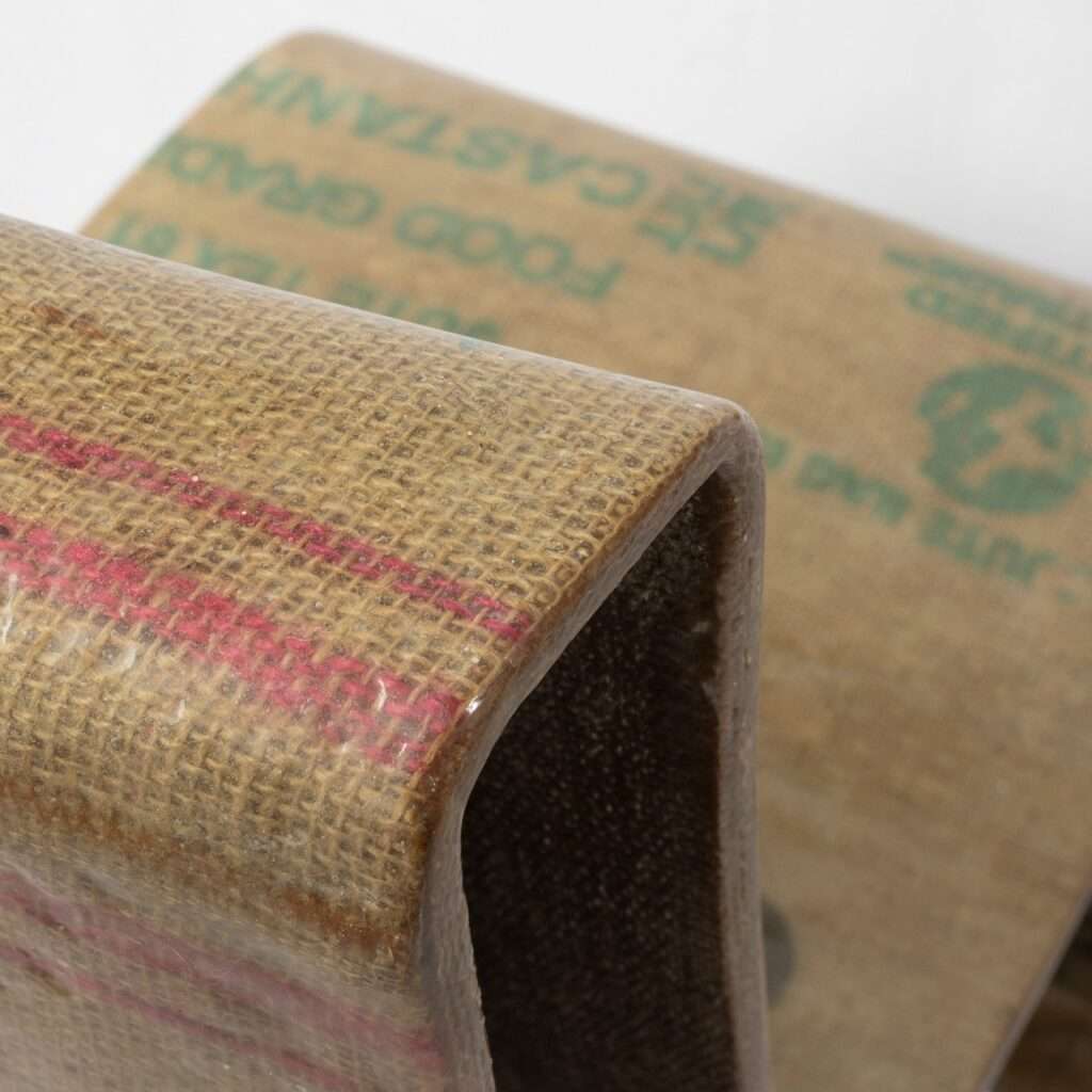 Top-down detail of the Novum Chair's backrest curve, showing the branding on the recycled jute sacks used in the composition.