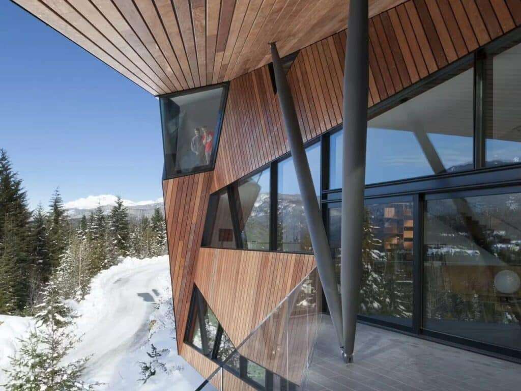 Exterior terrace of Hadaway House with prominent V-shaped steel supports and cedar wood cladding in winter.
