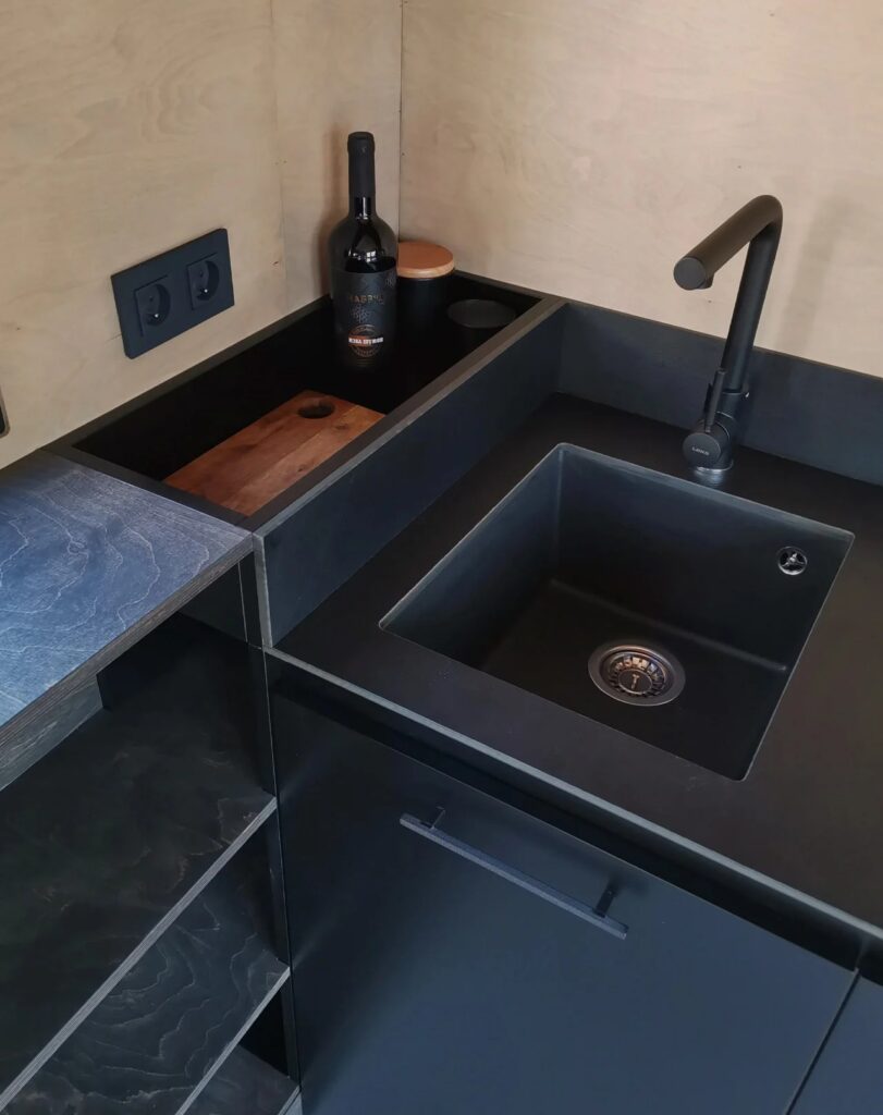 Top view of the integrated black sink and kitchen countertop in the compact Shoji House.