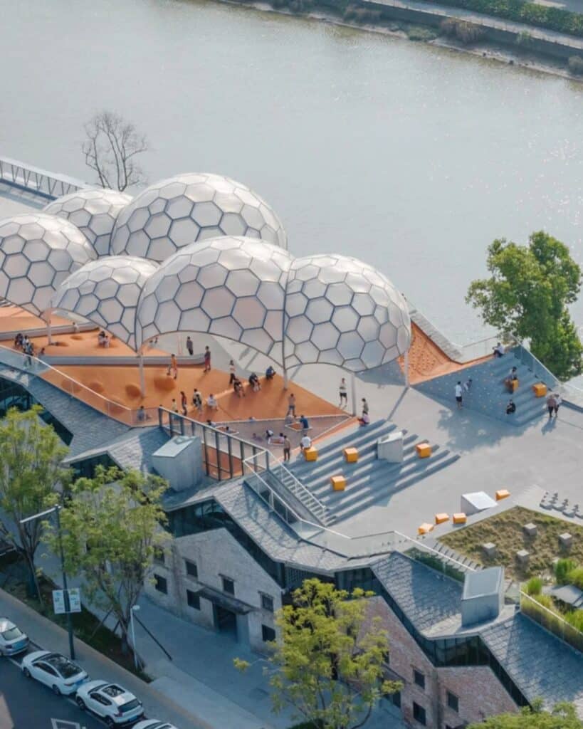 High-angle view of Yongping Warehouse renovation showing the relationship between the old granary roofs and the new elevated park.