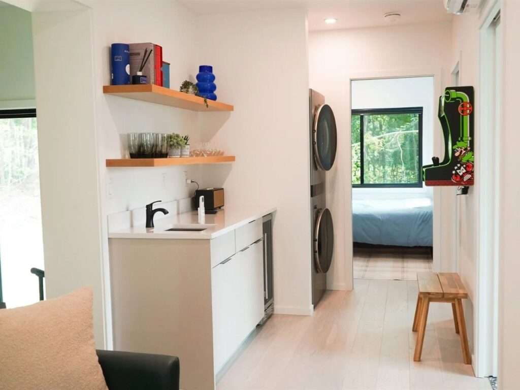 Interior corridor of Fairmont Villa with a wet bar, laundry units, and a view into a bright bedroom.