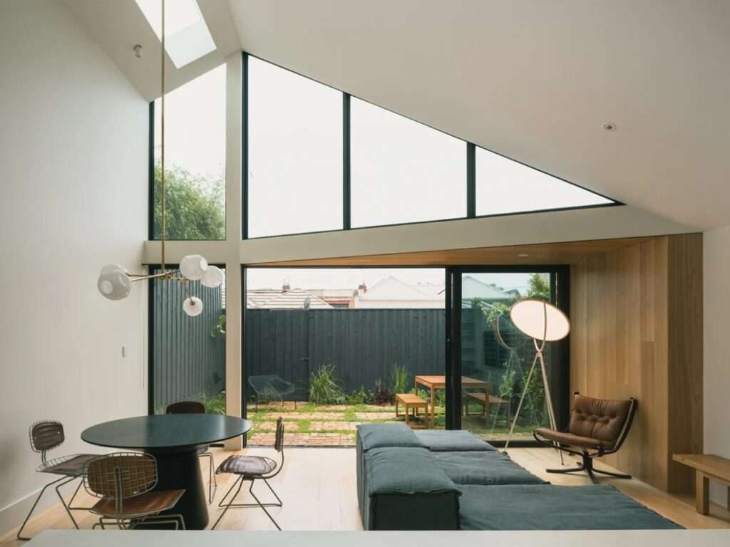 Wide interior view of the modern extension at Abbie Abbotsford Terrace showing the dining area, living space, and the courtyard connection.