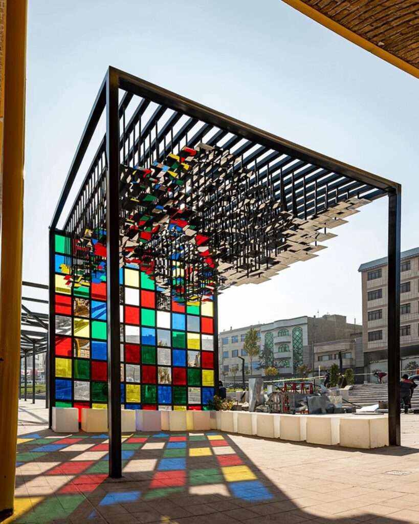 View of the Pavilion's interior shadows and the cubic frame against the backdrop of the industrial site.