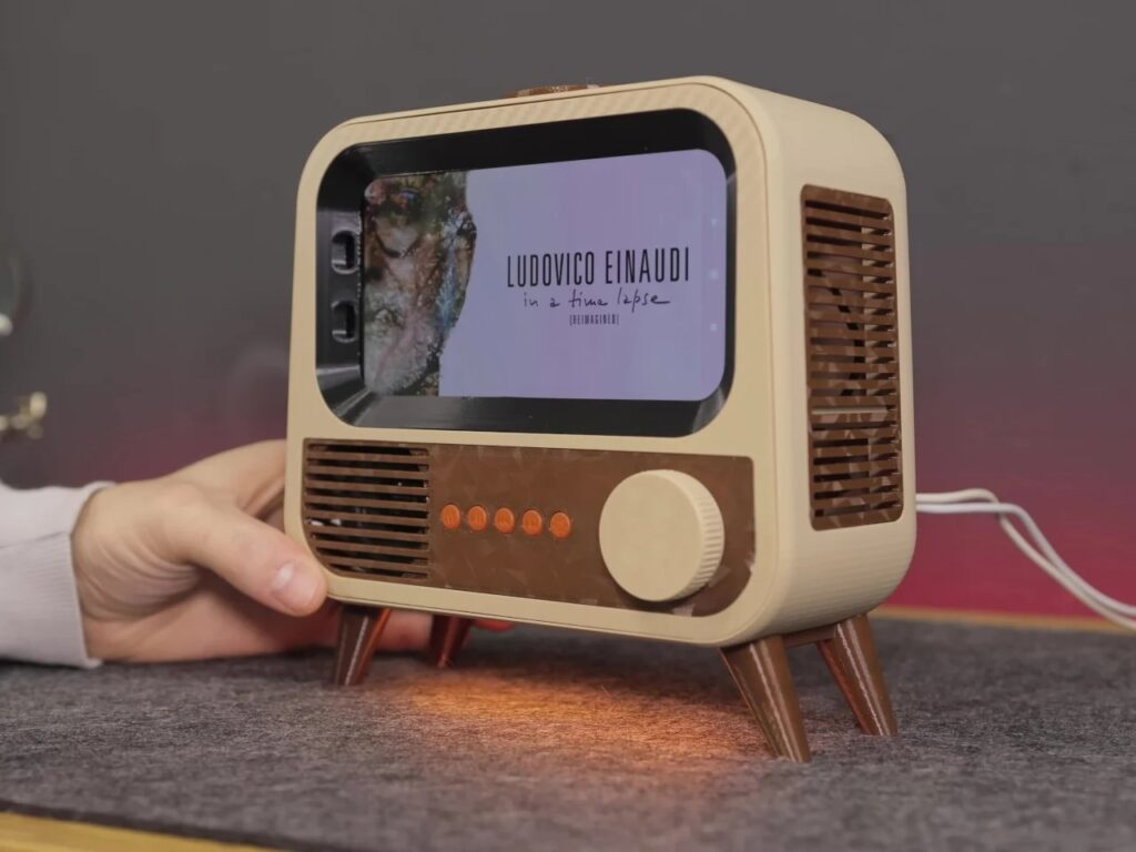 Repurposed Xiaomi Mi 8 smartphone screen inside a retro TV case playing music by Ludovico Einaudi with warm orange underlighting.