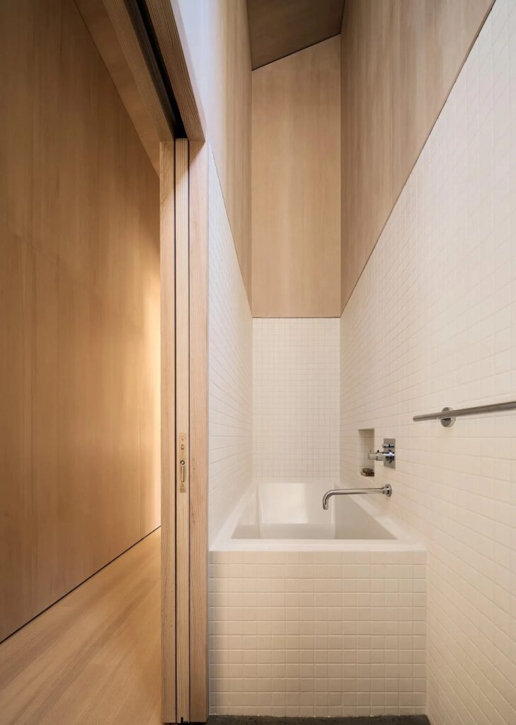 Modern minimalist bathroom with white mosaic tiles and Douglas Fir wood accents.