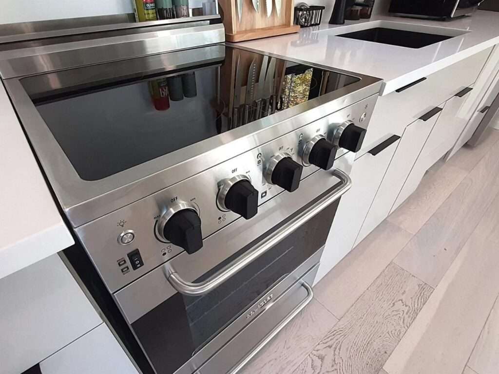 Close-up of a high-end stainless steel stove and oven integrated into a white kitchen countertop at Fairmont Villa.