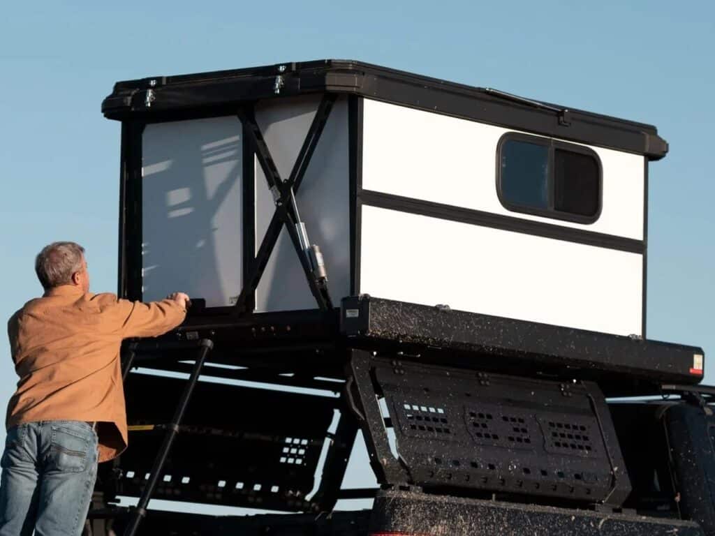 Close-up of the Altus cabin's white hardshell panels and black aluminum frame during the opening process.