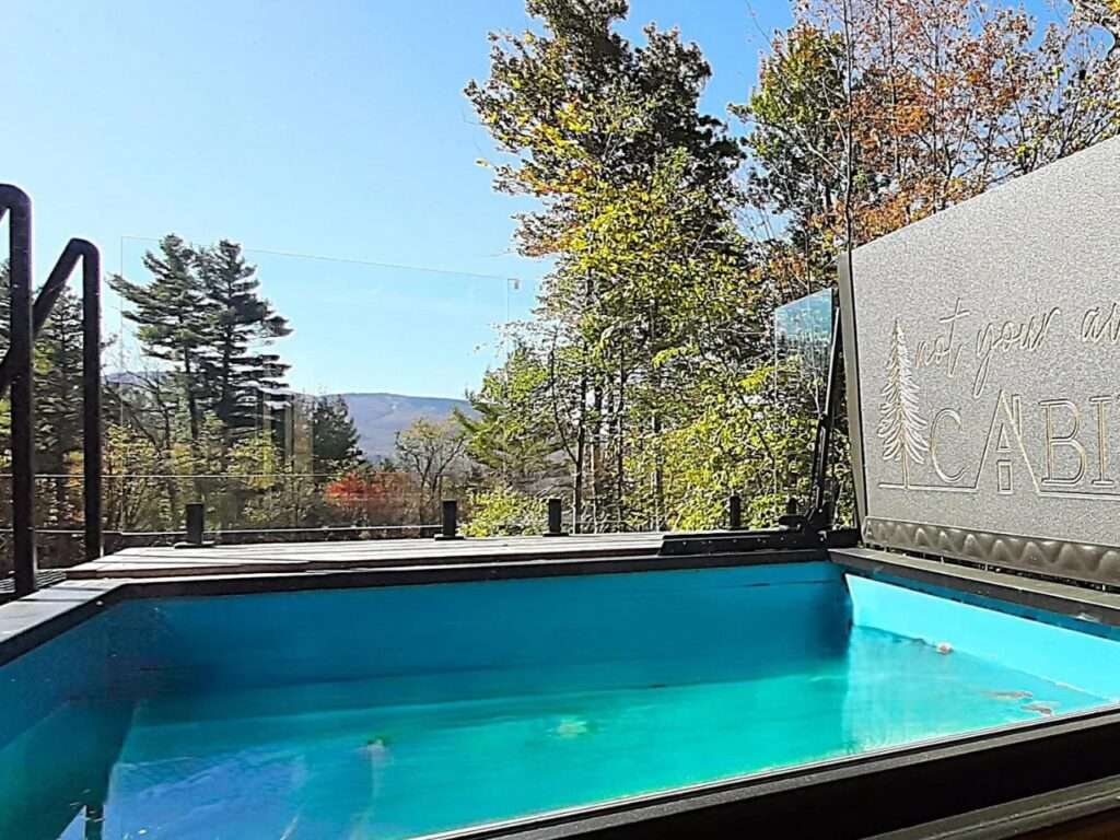 Close-up of the bright blue cold plunge pool on the rooftop of Fairmont Villa with a view of the forest.