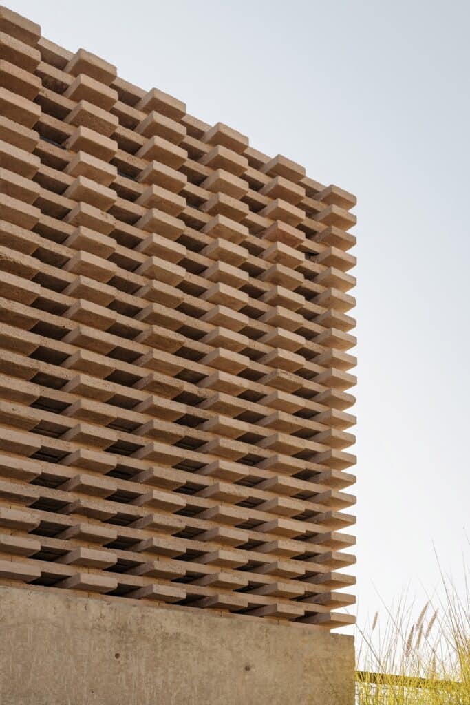 Close-up detail of the custom interlocking concrete block system (tongue and groove) in Capuchinas House facade.