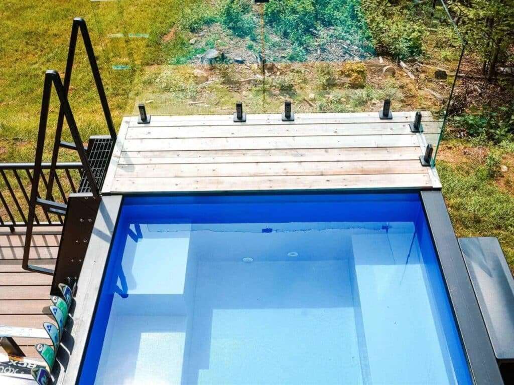 Top-down view of the cold plunge pool at Fairmont Villa with glass railings and wooden decking.
