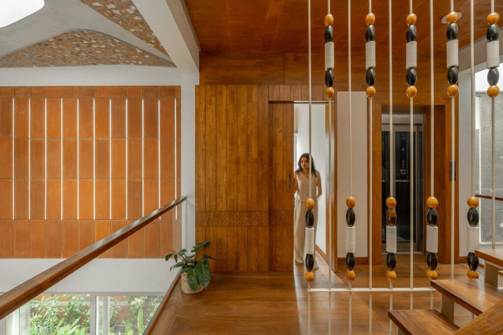 Interior detail featuring a sliding wooden door with geometric patterns and a modern elevator for future accessibility.