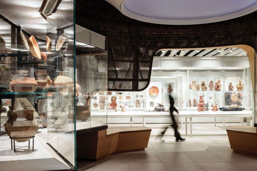 Indigenous ceramics gallery at Gardiner Museum with specialized lighting and wooden organic display structures.