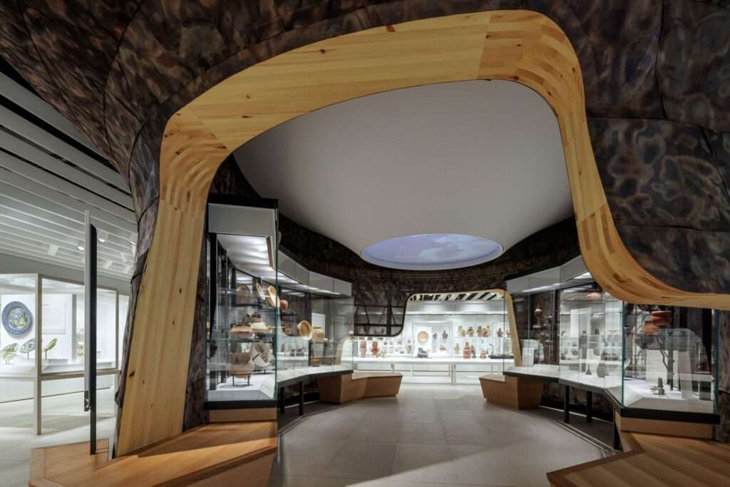 Close-up of the Indigenous gallery at Gardiner Museum featuring a circular ceiling light and organic wood paneling.