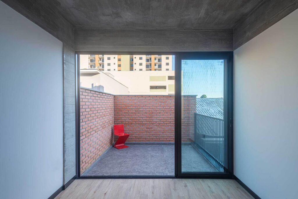 Minimalist rooftop terrace with brick parapet wall and view of the urban surroundings.
