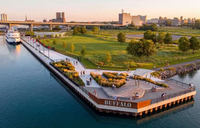 Aerial view of the Buffalo Cruise Terminal pier with docked vessel and waterfront park at sunset.