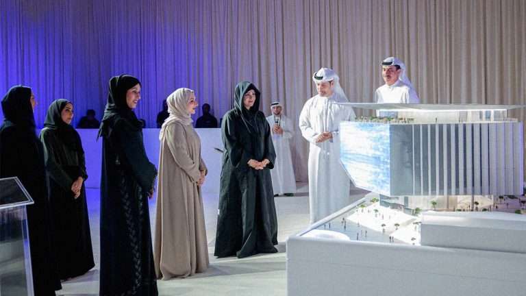 DIFC and Dubai Culture officials posing with MODA museum model and digital rendering backdrop