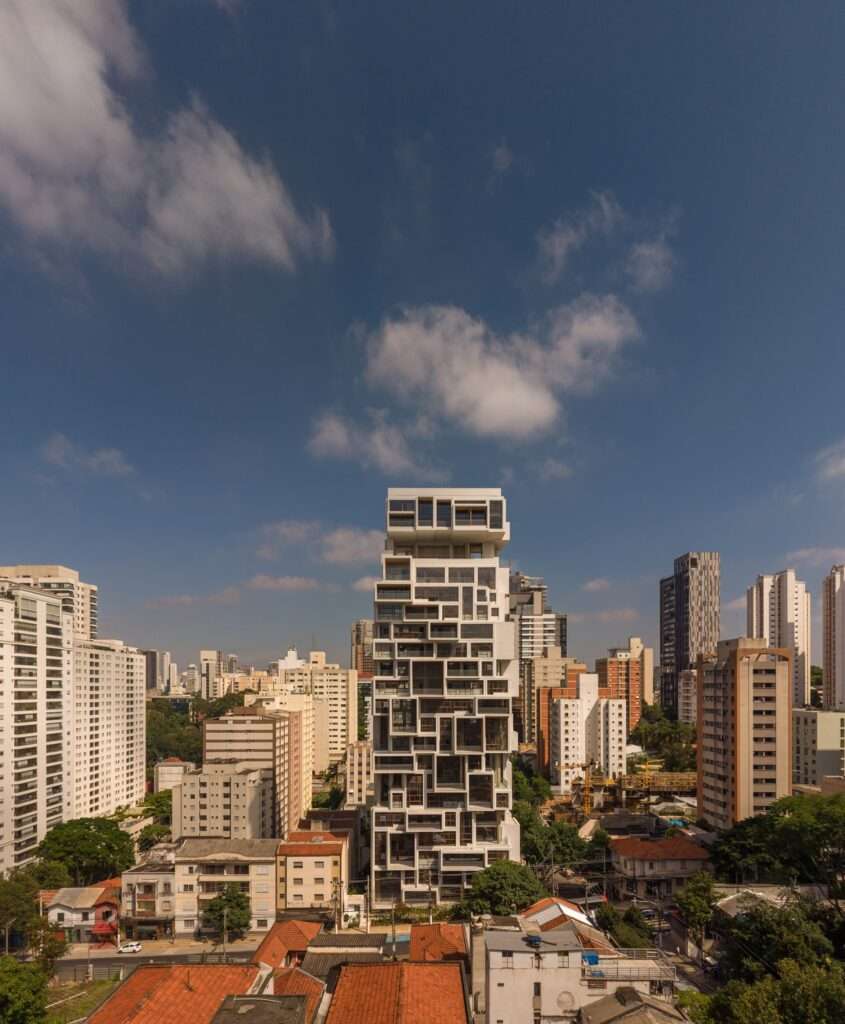 Front view of a white architectural tower with asymmetric rectangular projections and window grids.