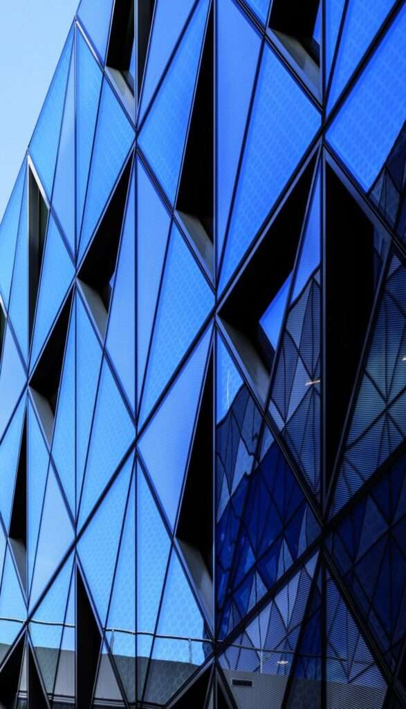 A close-up, angled shot of deep blue glass triangular cladding panels on a building facade.