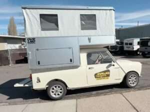 Side view of a vintage cream-colored Mini 95 pickup truck fitted with an expanded aluminum Ovrlnd Chubby pop-up camper shell in Flagstaff, Arizona.