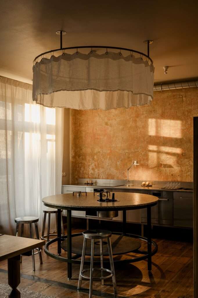 Dining area in P81 House featuring a custom oak table with details inspired by original railings and large-scale colorful wall art.