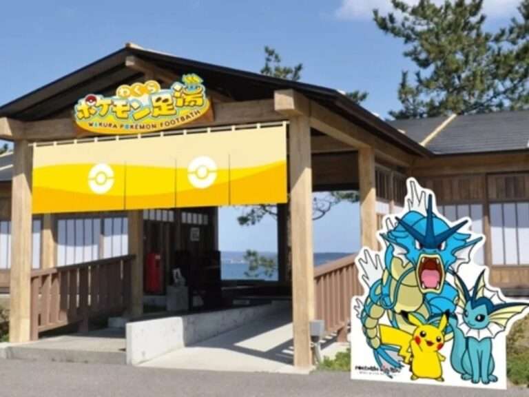 Entrance of the Wakura Pokemon Footbath in Nanao, Japan, featuring a wooden pavilion with a Gyarados and Pikachu cutout against a coastal backdrop.