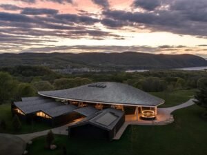 Aerial twilight view of the Samuel H. Scripps Theater Center roof structure embedded in the Hudson Valley landscape, designed by Studio Gang.