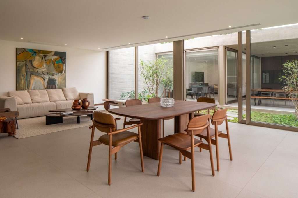 Dining area in Casa Jevio featuring modern furniture and views of the interior courtyard garden.