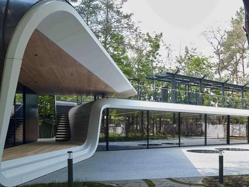 Exterior view of the private car collection garage by ATRIUM showing the fluid white Corian ribbon architecture and glass exhibition walls.