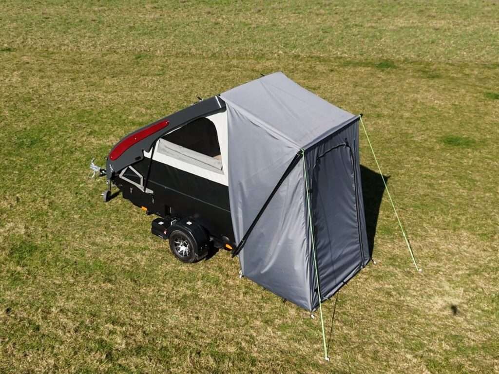 Aerial side view of the black Dashaway ECT trailer with a closed grey awning attached.