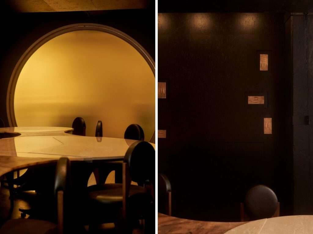 Close-up of bronze plaques by Nifemi Marcus-Bello on a black wall and a detailed view of the circular yellow door.