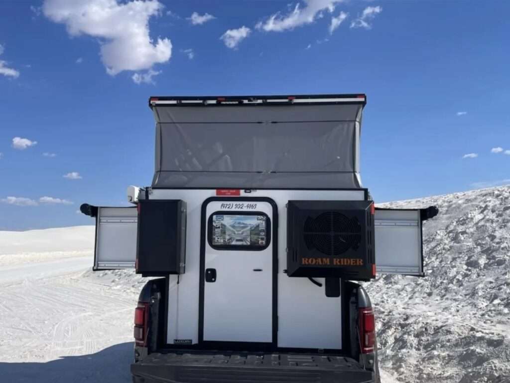 Interior view of the SL camper featuring white marble-patterned cabinetry, sliding storage units, and cushioned seating area.