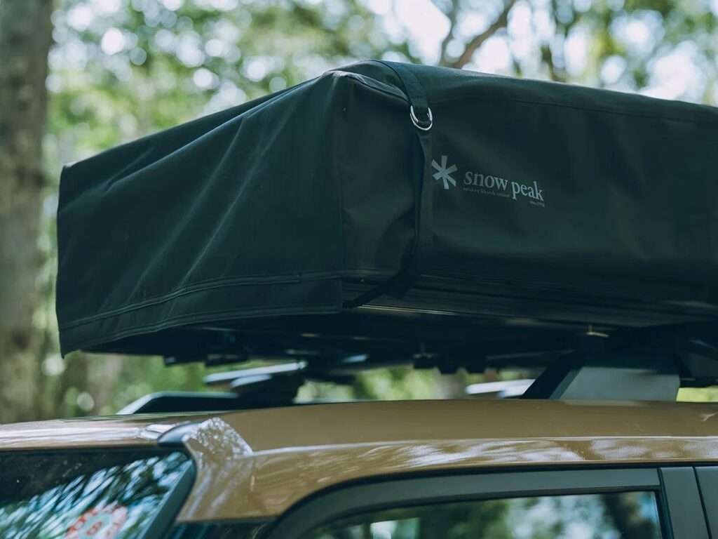 Close-up of the Fire Rise RTT folded into its compact black protective cover on the roof of a Toyota Land Cruiser.