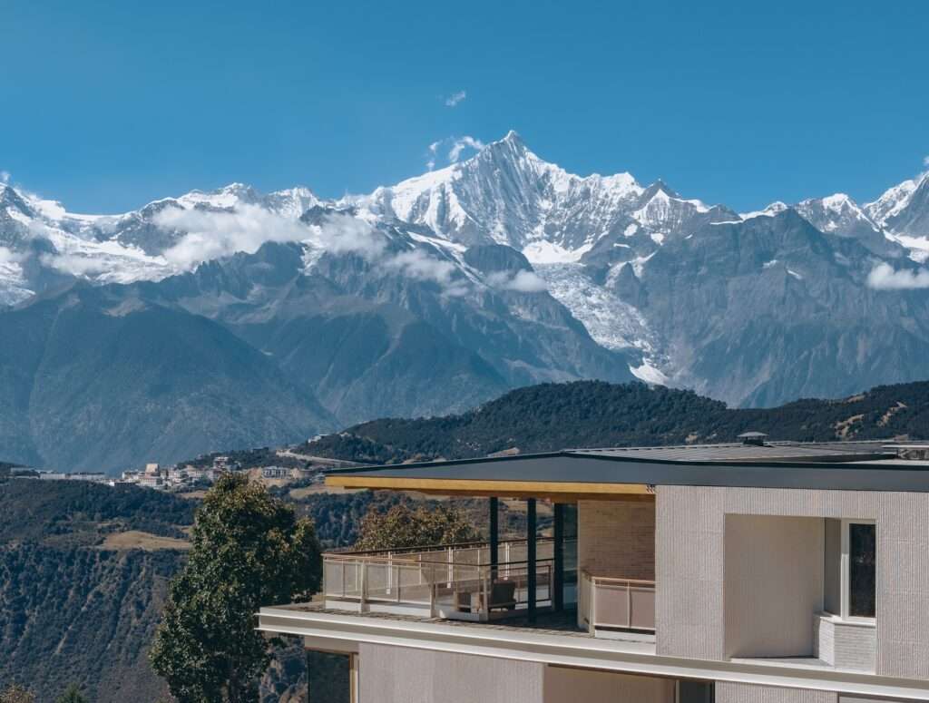 Top floor terrace of Kawagebo Snow Mountain Hotel overlooking the snowy peaks of Meili Mountain.