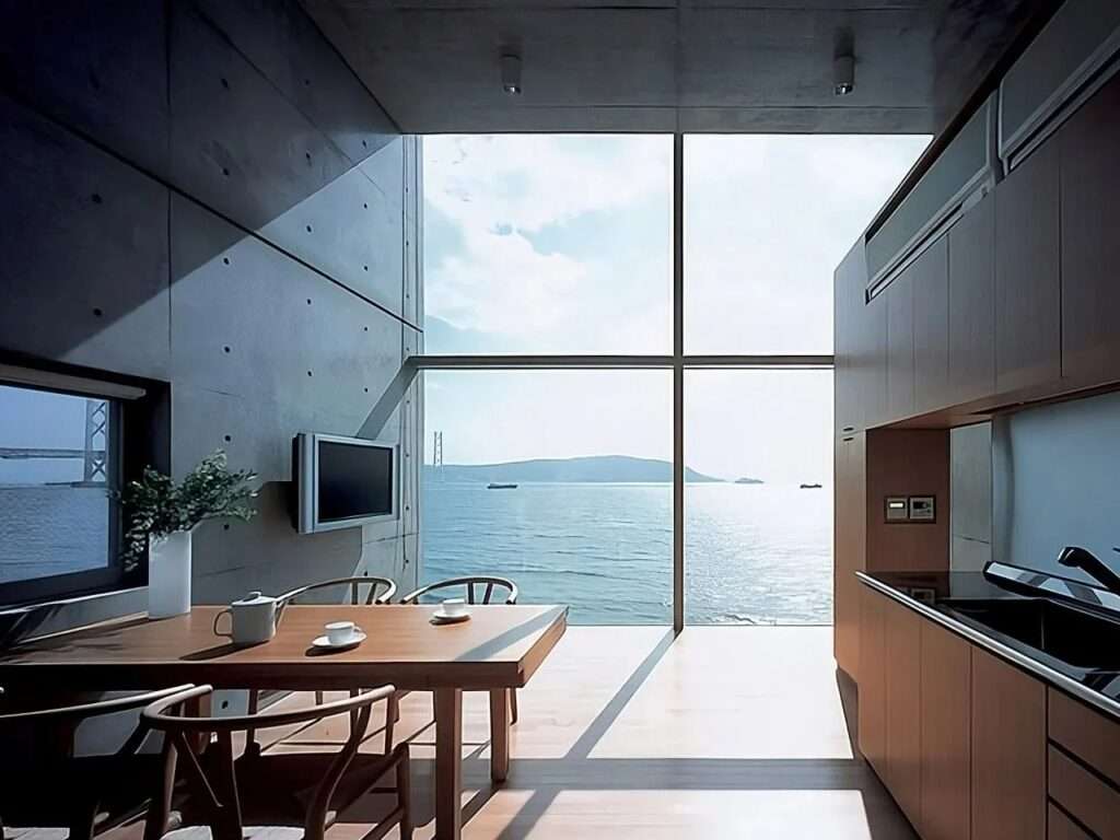 Minimalist interior of the 4x4 House top floor kitchen and dining space, featuring a massive floor-to-ceiling glass grid window looking out at the Seto Inland Sea.