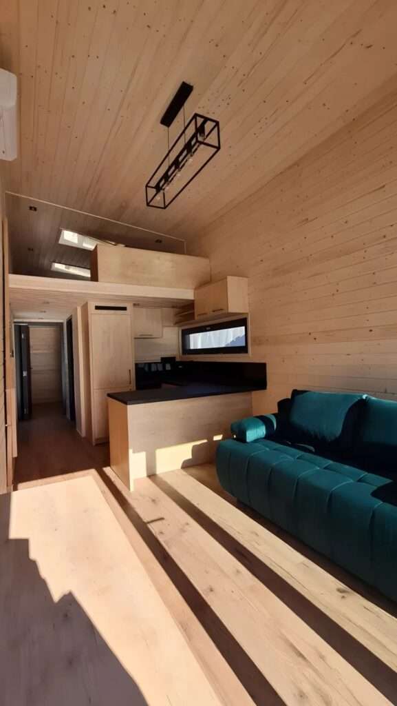Interior view of the Samuel tiny house showing the open-plan kitchen and the mezzanine level above.