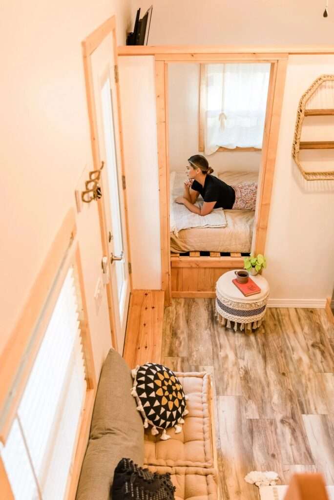 Elevated view showing the transition from the living space into the ground floor master bedroom of the Tulsi tiny home by Simplify Further.