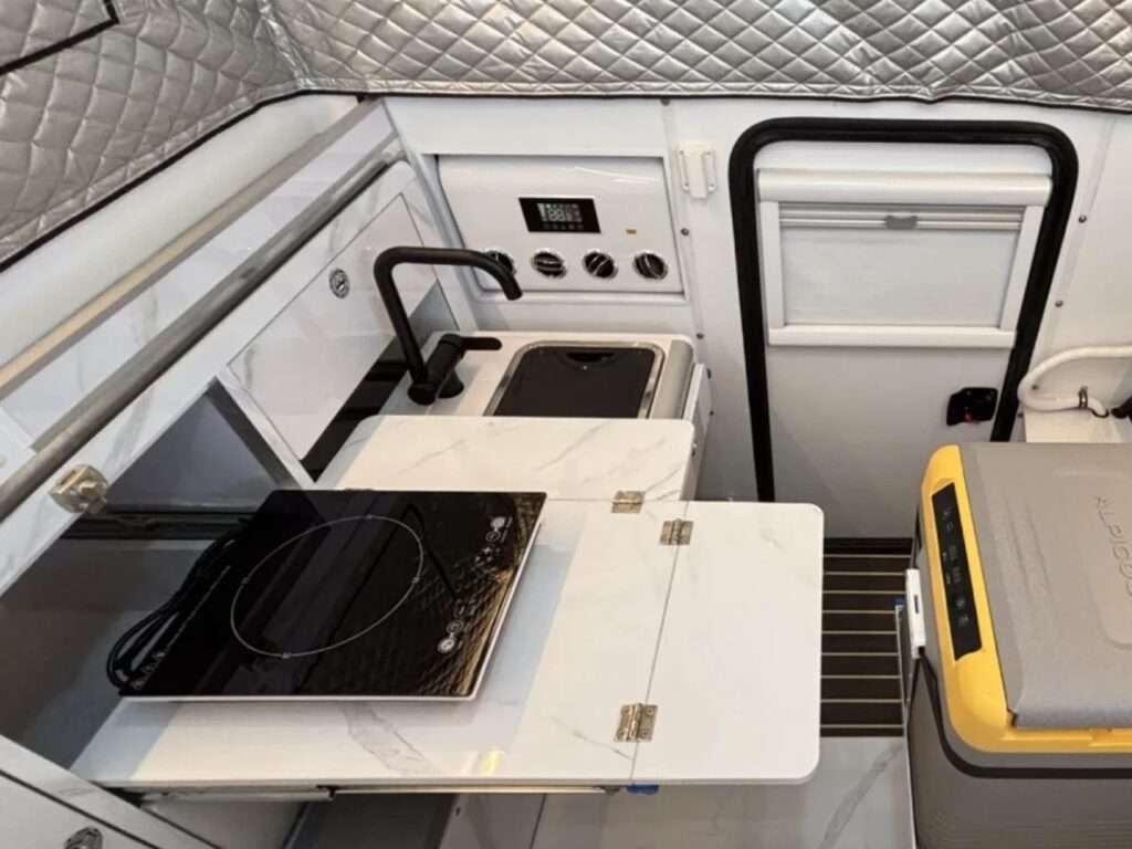 The main sliding bed of the Roam Rider SL camper, accommodating two people, surrounded by insulated quilted walls.