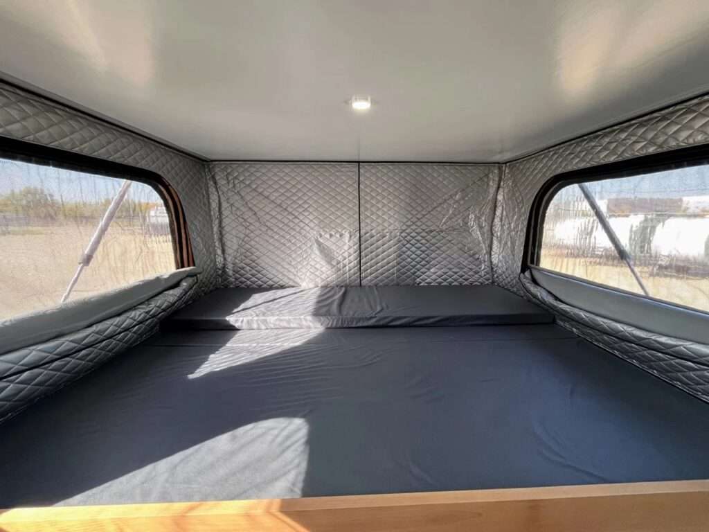 Functional kitchen setup in the SL camper with a 1500W induction cooktop on a drop-down surface and a matte black folding faucet.