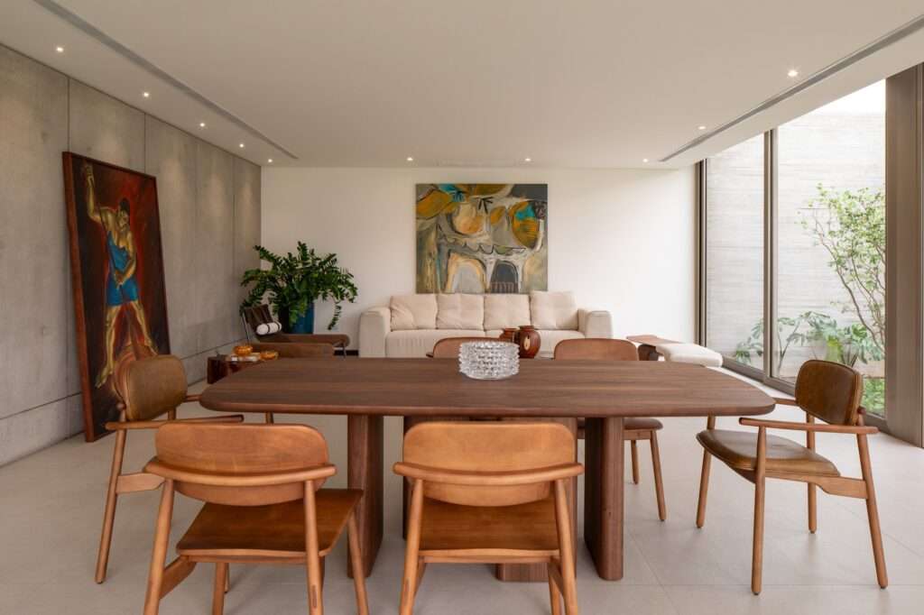 Interior dining area of Casa Jevio with concrete walls and wooden furniture.