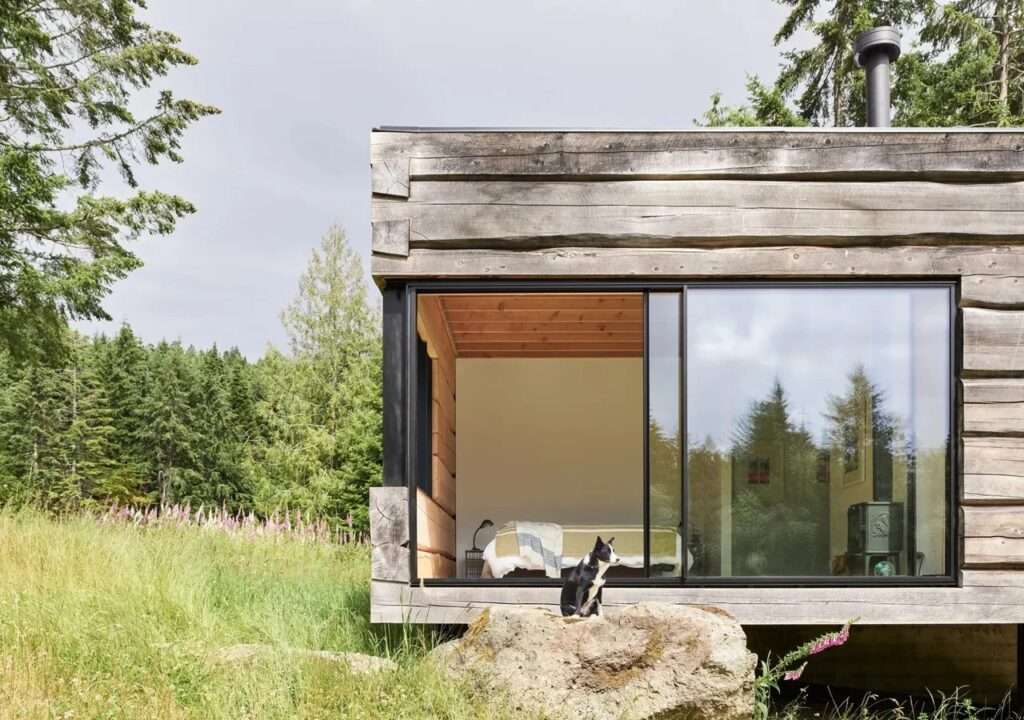 Close-up of the northern volume of Daisy House featuring reclaimed wood cladding and a large corner window.