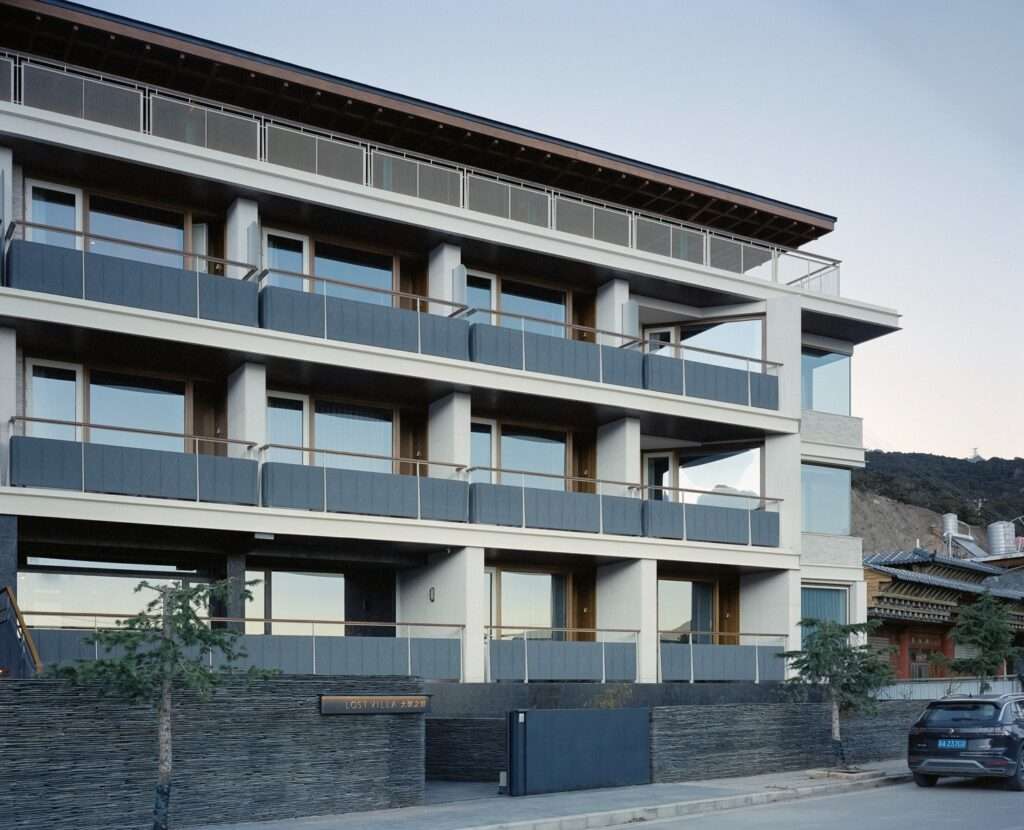 Front elevation of the Kawagebo Snow Mountain Hotel showing the guest room balconies and entrance wall.