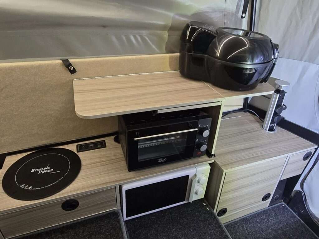 Internal view of Dashaway ECT kitchen area featuring a microwave, oven, and induction hob.