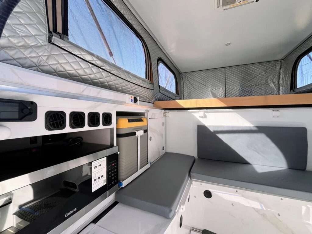 Interior control panel and dual-zone 12V refrigerator on a sliding platform inside the SL overland camper.