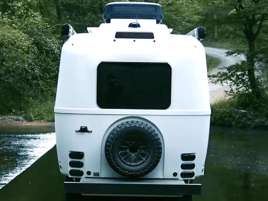 Rear view of the white Oliver Apex X23 trailer showing the mounted spare tire and LED tail lights.