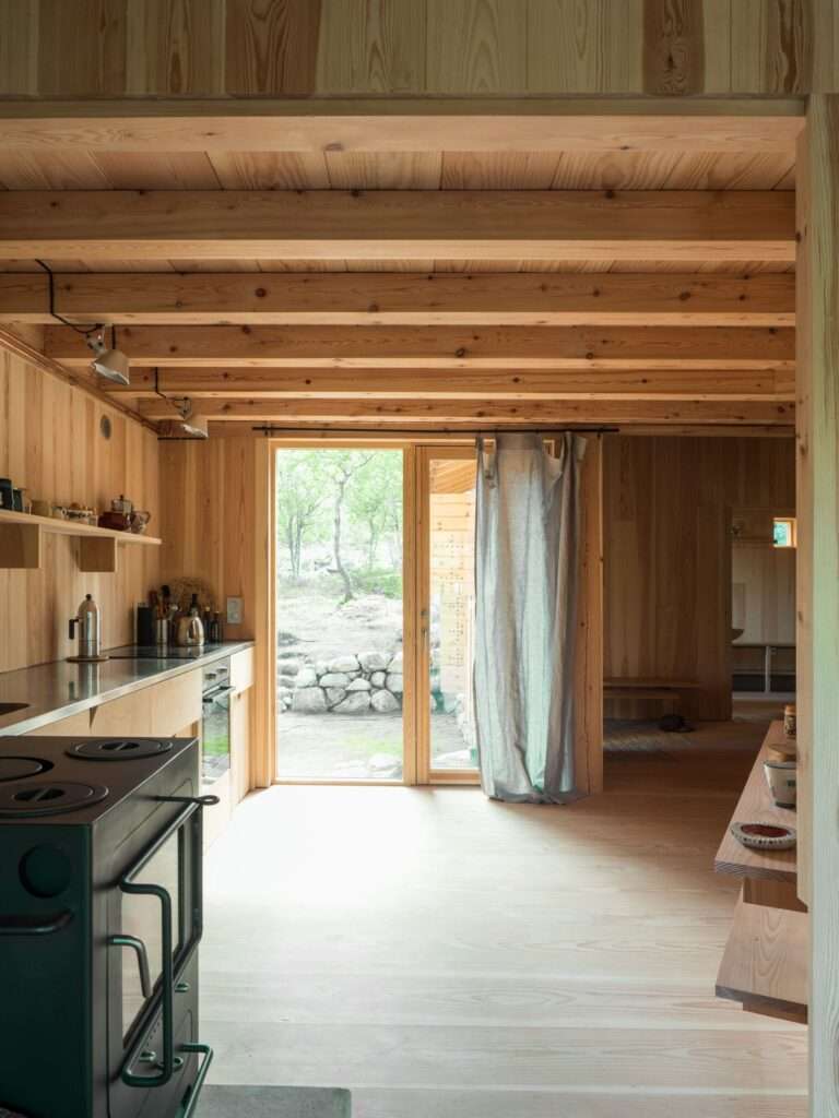 View from the interior kitchen looking out towards the forest through a glass door in the Timber Temple.