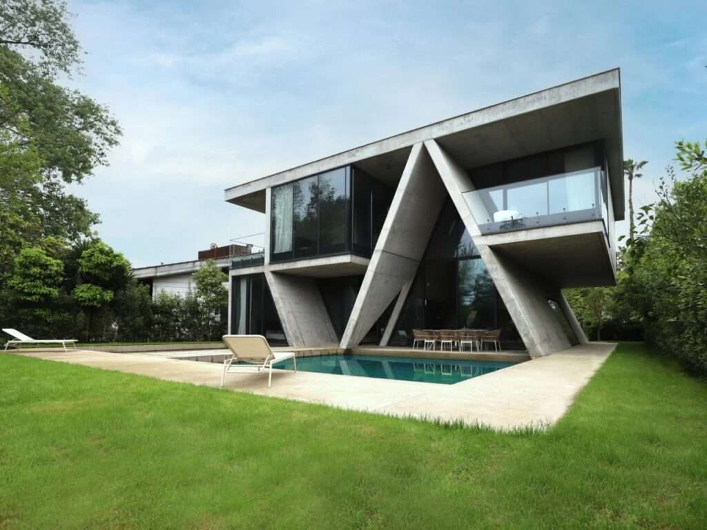 Angled architectural photograph of Gable Villa showcasing its deep cantilevers, swimming pool, and concrete frame from a low vantage point.