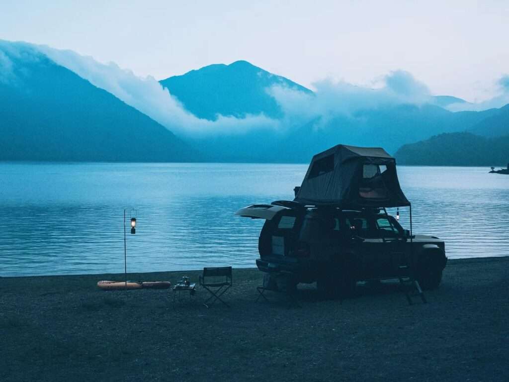 Silhouette of a vehicle with the Fire Rise RTT deployed at sunset by a lake.